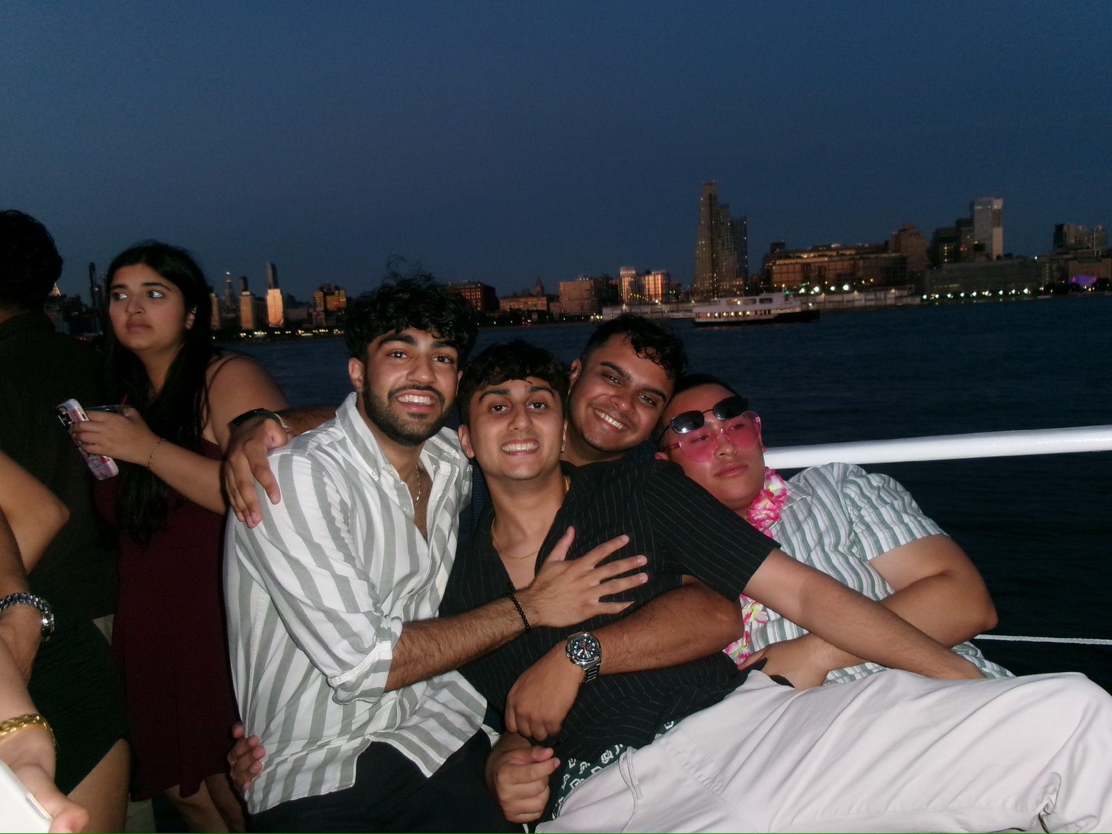 Friends on a boat at dusk with a city skyline